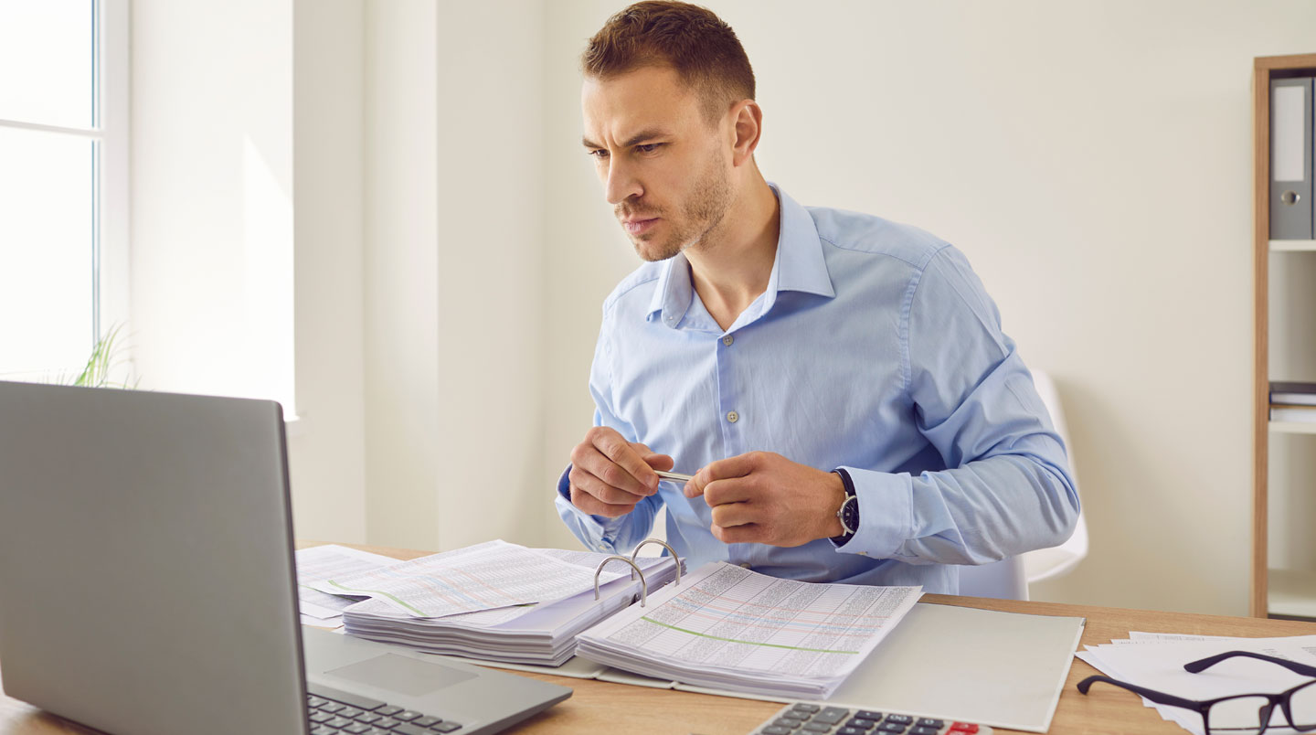 Gros plan sur une feuille de tableau de bord financier avec des chiffres floutés et un stylo posé sur un bureau moderne